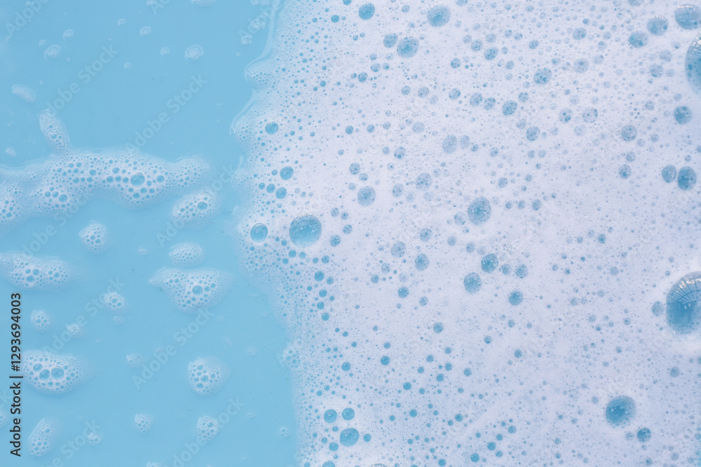 Wall mural Foam on blue background. Liquid soap bubbles