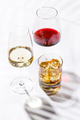 A refined composition of wine glasses filled with red and white wine, paired with a whiskey glass