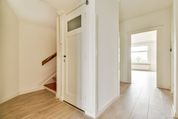 A well-lit hallway showcasing minimalistic design with wooden flooring and fresh white walls, leading to a cozy living area.