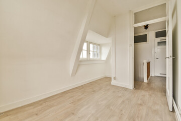 A bright, spacious empty room featuring minimalist design elements, large windows allowing natural light, and light wooden flooring, perfect for various uses.