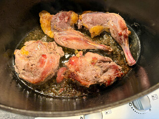 Roasted pheasant legs and breasts in black pan