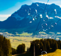 Alpine summer view with soap bubbles in front of Mount Zugspitze, Top of Germany, Garmisch-Partenkirchen, Bavaria, Germany