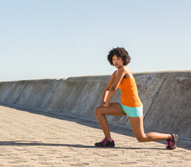 African American woman stretching on promenade, preparing for morning workout, copy space