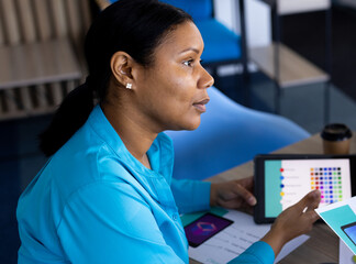 Businesswoman discussing color palette using tablet in modern office meeting