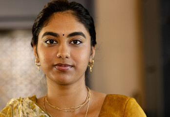 Confident Indian woman in traditional attire looking at camera at home