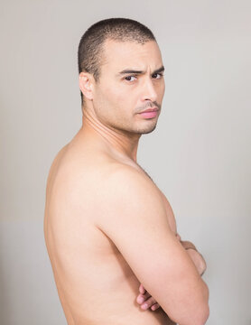 Confident man with arms crossed looking over shoulder at home