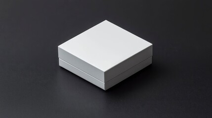 Minimalist white box sitting on a dark surface, gift packaging. Presentation stock photo