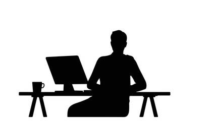 Silhouette of person sitting at desk with computer