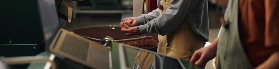 Obraz premium Website banner with unrecognizable workers launching roaster machine and grabbing coffee beans to check roasting level