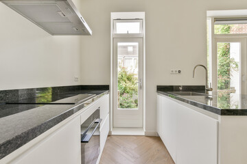 A sleek and modern kitchen showcasing minimalist design with elegant cabinetry and large windows for natural light. Perfectly stylish and functional.