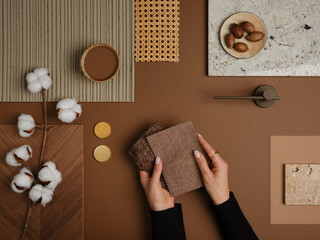 Warm-toned material mood board with natural textures, cotton branches, and fabric samples for interior design inspiration.