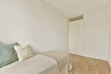 Fototapeta premium A clean, minimalist room featuring simple decor and neutral tones, emphasizing a sense of space and calm. The light-colored walls complement the light wooden floor.