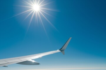 Fototapeta premium Private jet wing sun glinting off its edge, clear blue sky background 