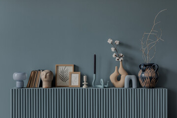 Elegant shelf arrangement with modern vases, framed botanical prints, and decorative objects in a...