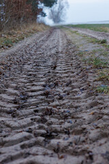 ślady po ciągniku rolniczym na piaszczystej drodze polnej