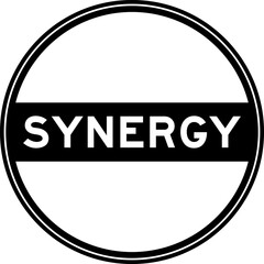 Black color round seal sticker in word synergy on white background