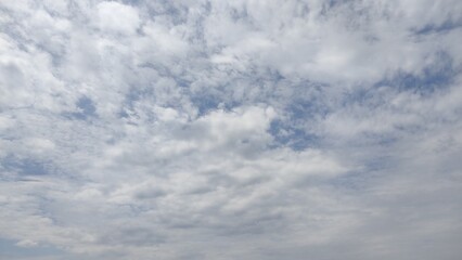 Obraz premium Soft cloudy sky with scattered white clouds and patches of blue. A peaceful and airy atmosphere, perfect for backgrounds, weather concepts, and nature-themed designs