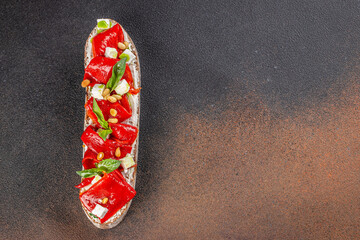 Vegan bruschetta with slices baked red pepper, feta cheese and greens, top view