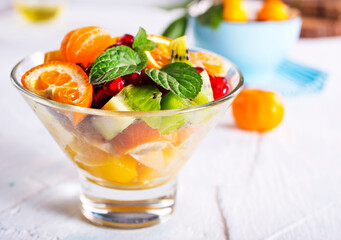 Bowl of healthy fresh fruit salad on pink background,