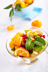Bowl of healthy fresh fruit salad on pink background,