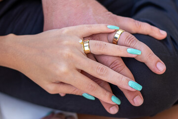 Hands of a young woman with a wedding ring over a man's hand with a wedding ring symbolizing marriage