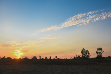 the serene and peaceful moment of sunset. The sun's warm orange and yellow hues spread across the horizon, blending seamlessly into the deep blue sky.