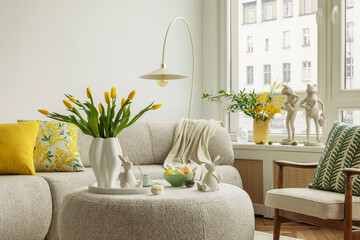 A round ottoman with a marble tray holds pastel eggs, ceramic bunnies, and a cup of coffee. Home...
