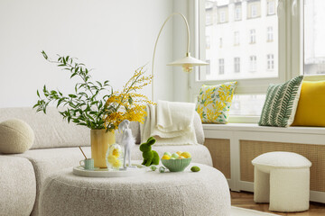 Bright living room with an Easter setup featuring yellow tulips in a white vase, soft textured...