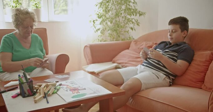 Grandmother and grandson bond over a card game, showcasing love, connection, and quality family time. Perfect for projects on family, childhood, and inter generational relationships.