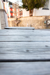 Aged wood texture in street interior - close-up of grey wooden boards on a table with blurred background, copy space,