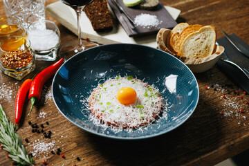 Artisanal beef tartare crowned with a raw egg yolk and Parmesan shavings. Complemented by toasted bread, red chili peppers, and rosemary. A sophisticated dish for gourmet lovers