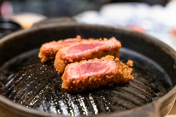 This Japanese-style fried beef steak, known as Gyukatsu, is a mouthwatering dish featuring a perfectly crispy, golden-brown crust with a tender, juicy interior. Cooked to perfection on a sizzling hot 