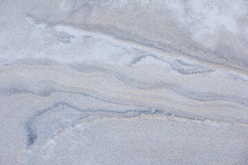 
light blue quartzite colored sand surface with gray and dark blue vein patterns.