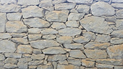 Natural stone wall background with a rough texture. Perfect for design, backgrounds, wallpapers, and texture overlays