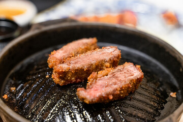 This Japanese-style fried beef steak, known as Gyukatsu, is a mouthwatering dish featuring a perfectly crispy, golden-brown crust with a tender, juicy interior. Cooked to perfection on a sizzling hot 