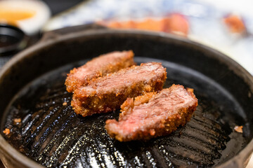 This Japanese-style fried beef steak, known as Gyukatsu, is a mouthwatering dish featuring a perfectly crispy, golden-brown crust with a tender, juicy interior. Cooked to perfection on a sizzling hot 