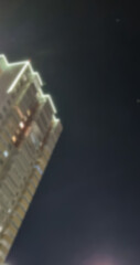 View from below of a blurred multi-story brick building at night