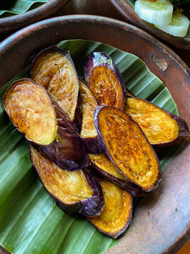 Pile of fried eggplant served on a earthenware plate.