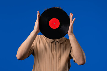 Young Man Hiding Head, Vinyl Record Disc On blue. Hobby, Music Lover, Collection