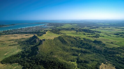 Naklejka premium A top-down view of Auckland's landscape, with clear blue skies, urban sprawl, and lush green areas.