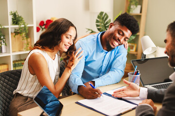 Obraz premium Happy couple smiling and signing contract with financial advisor