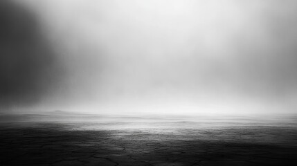 Soft-focus fog spreading over a barren landscape, with distant hills obscured in the mist for a dramatic effect.