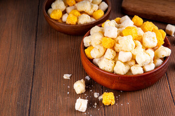 Various freeze dried cheese snacks, high protein, gluten-free, keto-friendly snack in wooden bowl, tasty salty snack for party or movie night