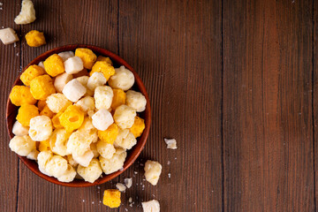 Various freeze dried cheese snacks, high protein, gluten-free, keto-friendly snack in wooden bowl, tasty salty snack for party or movie night