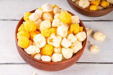 Various freeze dried cheese snacks, high protein, gluten-free, keto-friendly snack in wooden bowl, tasty salty snack for party or movie night