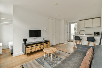 A sleek modern living room featuring neutral tones and minimalist furniture. The space showcases an inviting atmosphere with ample light and contemporary design.