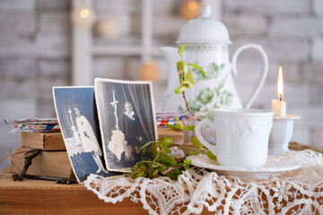 vintage photos, teapot, Antique tea set with lit candle on table, nostalgic atmosphere and inviting...