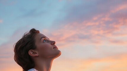 person gazes upward thoughtfully against backdrop of twilight sky symbolizing aspirations towards boundless expanse