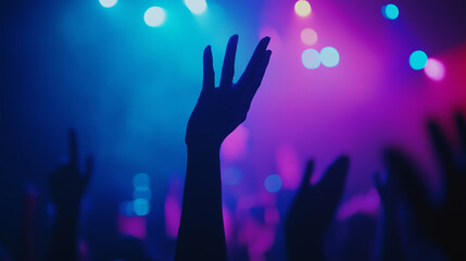 A dimly lit concert or worship event with vibrant stage lighting in blue, purple, and pink tones.