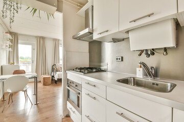 A stylish modern kitchen featuring sleek cabinets, a gas stove, and an organized dining area that complements the minimalist decor.